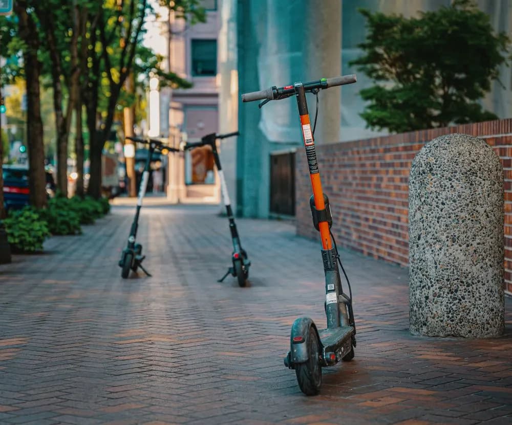 Patineta eléctrica con mástil naranja en una calle urbana