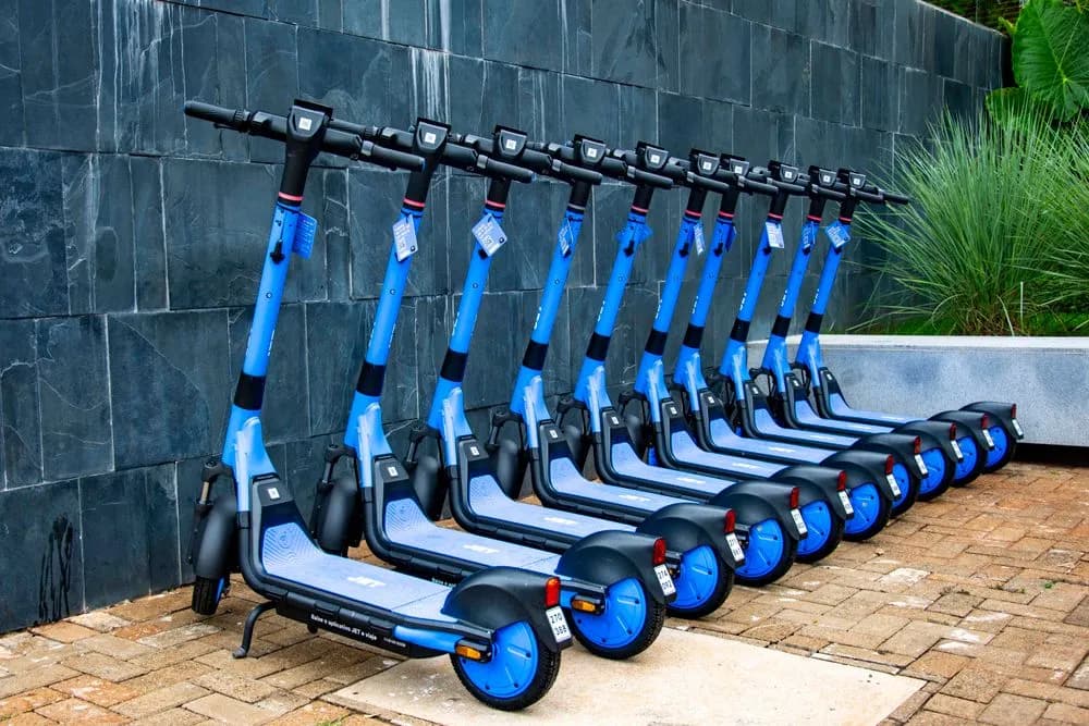 Fila de patinetas eléctricas azules estacionadas